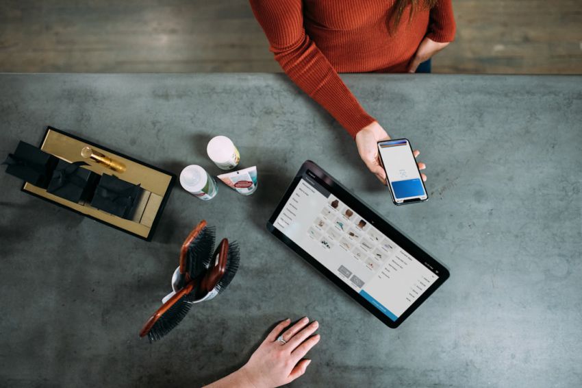 Mobile Payments - person holding smartphone beside tablet computer