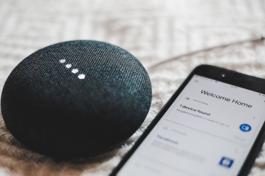 IoT - turned-on charcoal Google Home Mini and smartphone