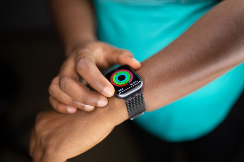 Wearables - person wearing silver aluminum case apple watch with white sport band