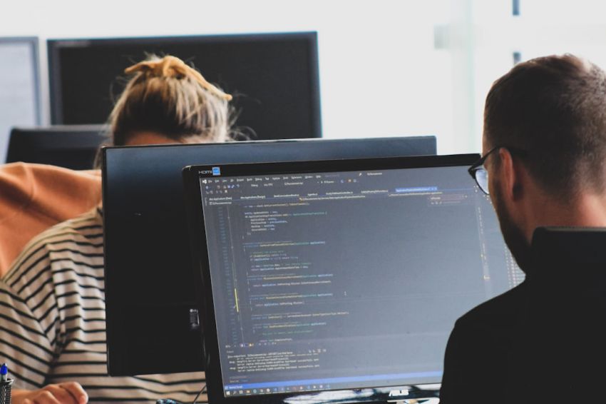 Computing - woman in black shirt sitting beside black flat screen computer monitor