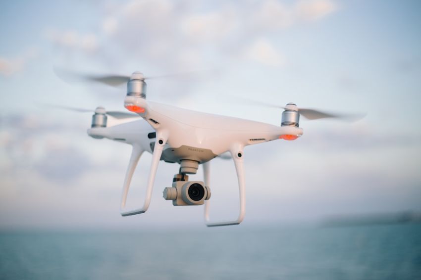 Drone - close up photography of drone flying over body of water at daytime